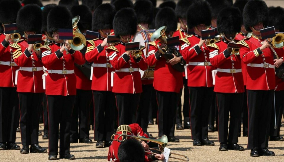 En musiker ses her liggende på jorden under prøverne, alt imens de øvrige i militærorkestret blot spiller videre.