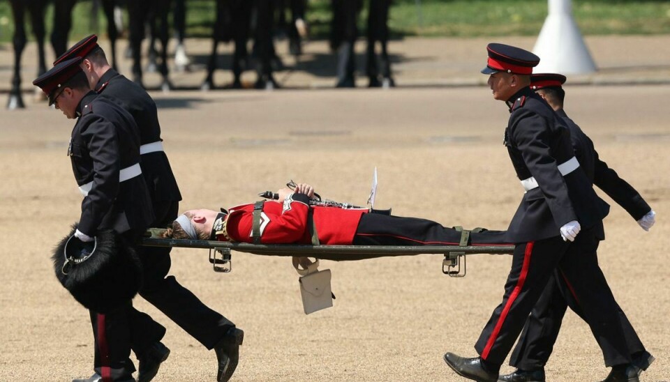 En soldat er ramt af hedeslag og må bæres væk på båre.