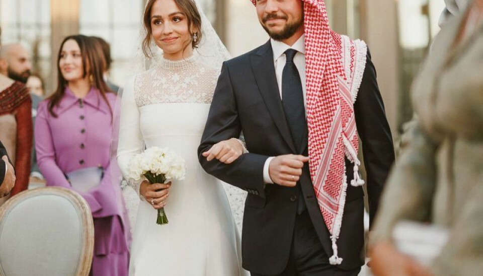 Prinsesse Iman føres ind til ceremonien af sin ældre bror, kronprins Hussein.