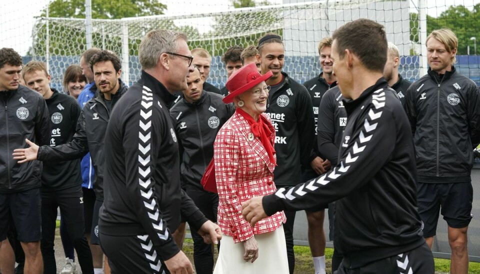 Her sender dronningen et varmt blik til DBU-kommunikationschef Jakob Høyer.