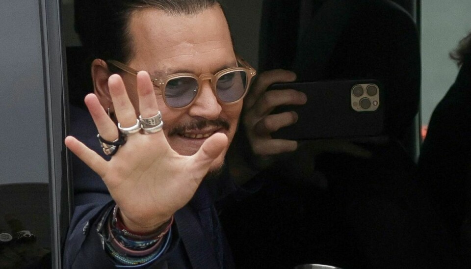 Johnny Depp hilser på sin fans, da han fredag ankommer til retten.