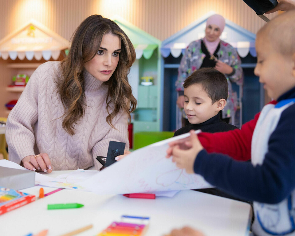 Dronning Rania lytter interesseret til et af de kræftramte børn under sit besøg på King Hussein Cancer Center