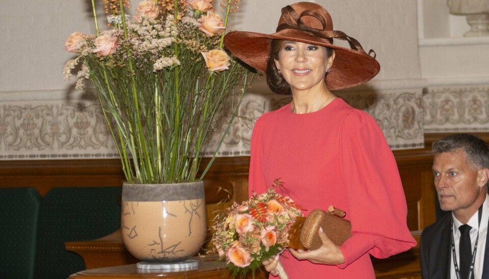 Dronning Mary i sin koralrøde Andrew GN-kjole lyste op i et smil før der blev taget hul på grundlovstalerne i Landstingssalen.