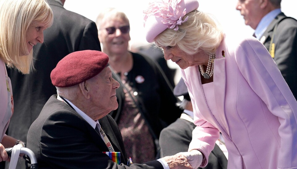 Dronning Camilla hilser på en af de deltagende veteraner, der var med ved den barske landgang i Normandiet i 1944.