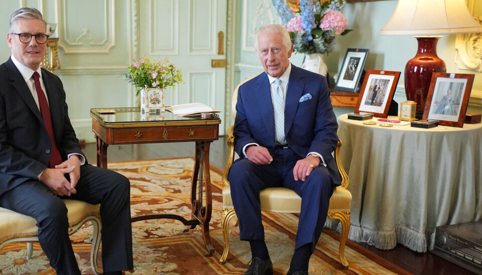 Storbritanniens nye premierminister Keir Starmer ses her i audiens hos kong Charles på Buckingham Palace fredag. Til højre - i den røde cirkel - ses portrætfotoet af dronning Margrethe.