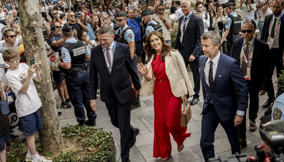 Frederik og Mary ankommer til åbningen af Den Danske Pavillon. Han i blåt jakkesæt og hun i knaldrød jumpsuit og hvid blazer.