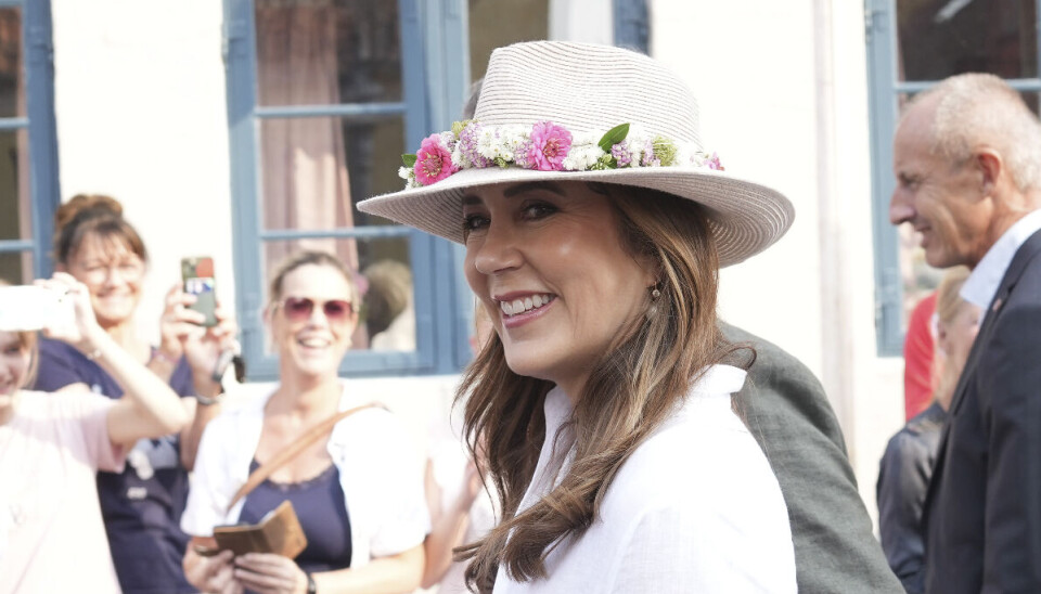 Og her ses dronningen så med sin blomsterkrans gjort fast på hatten.