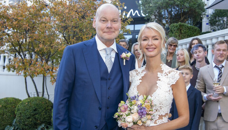 Parret foran Nimb med bryllupsgæsterne i baggrunden.