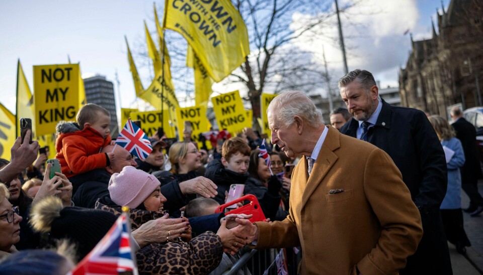 Charles ses her hilse på royale fans alt imens modstandere af monarkiet demonstrerer i baggrunden.