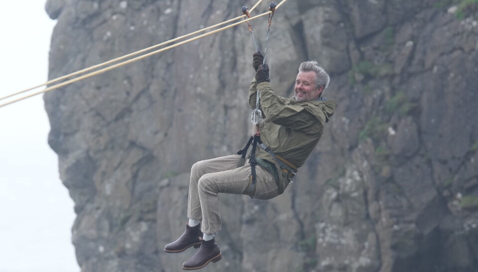 Kong Frederik ser unægteligt ud til at more sig kosteligt, mens han glider ude over kløften.