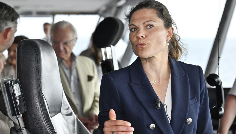 Victoria ses her ombord på M/S Aurora. I baggrunden kan man ane kong Carl Gustaf og dronning Silvia.