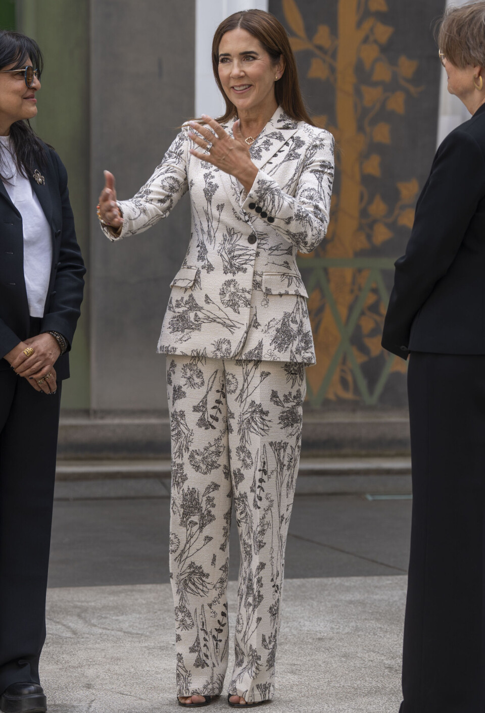 Elegant klædt Dronning Mary kigger på udstillingen