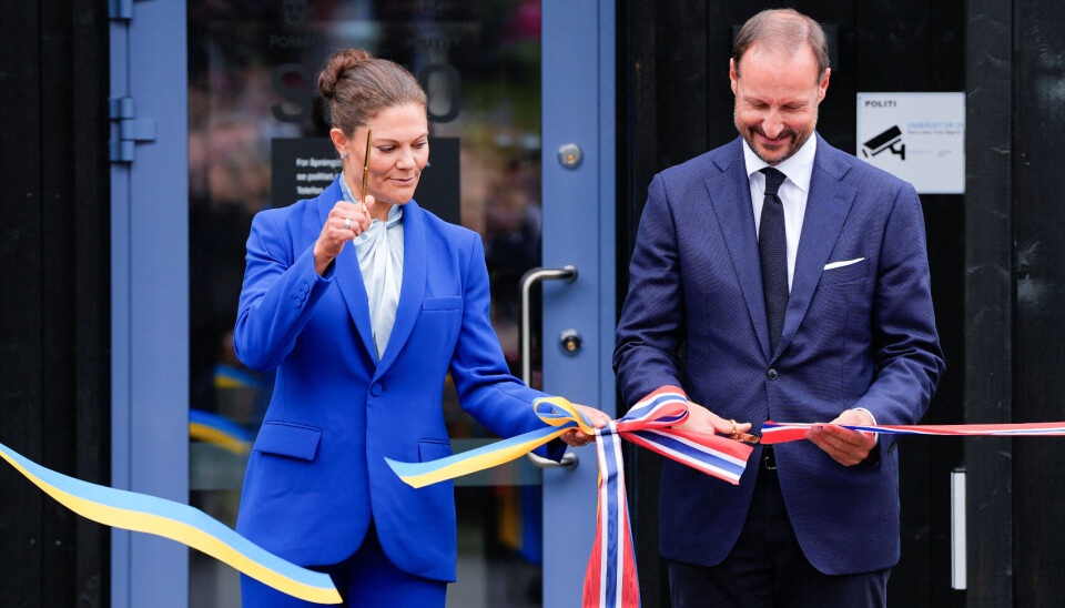Kronprinsesse Victoria og kronprins Haakon, med hver sin saks, klipper, båndet og erklærer den fælles svensk-norske politistation for åben.