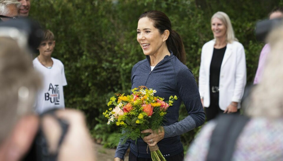 Mary bliver budt velkommen i tennisklubben med blomster.